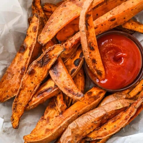 close up shot of air fryer sweet potato wedges with ketchup.